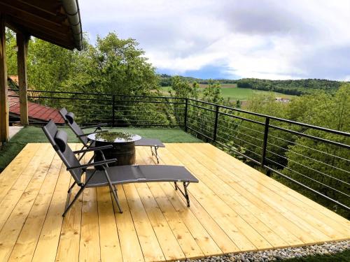 una terraza de madera con una silla y una mesa. en Papa Franks House, en Ptuj