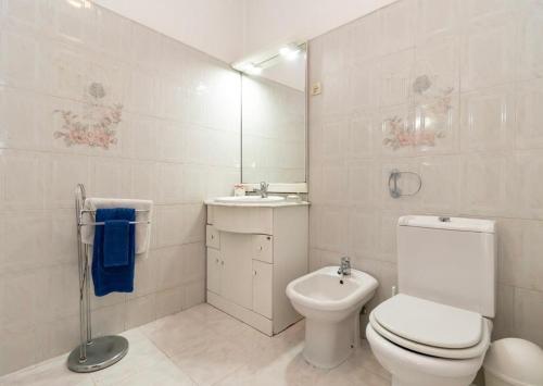 a white bathroom with a toilet and a sink at Amazing Getaways in Amora