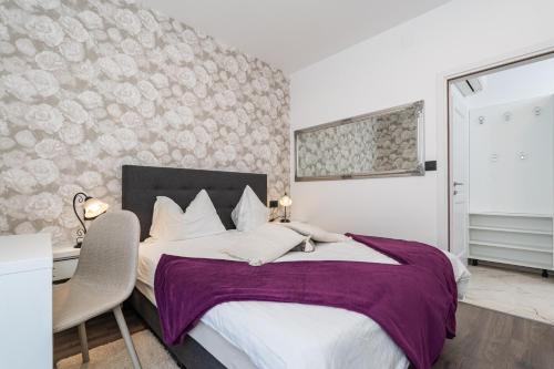 a bedroom with a large bed with a desk at Apartments Villa Palma in Mlini