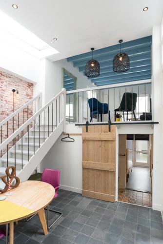 a room with a staircase and a table and chairs at Pakhuis aan de Zaan in Wormerveer