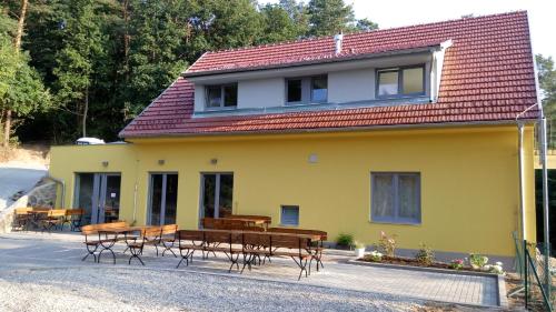 a yellow house with tables and chairs in front of it at Mezi Stromy in Brno