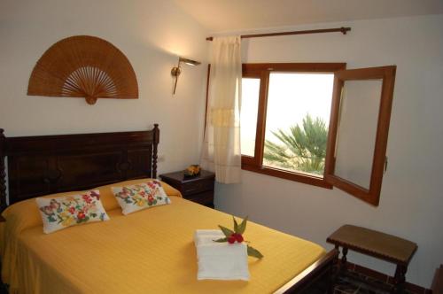 ポルト・ダルクディアにあるApartamento Rosellaのベッドルーム1室(黄色いベッド1台、窓付)
