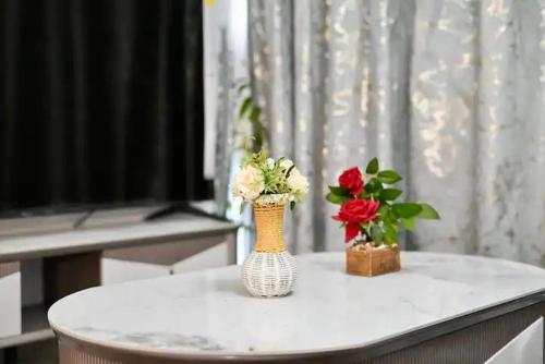 une table avec deux vases avec des fleurs dans l'établissement Al Wahid Holiday Homes, à Dubaï