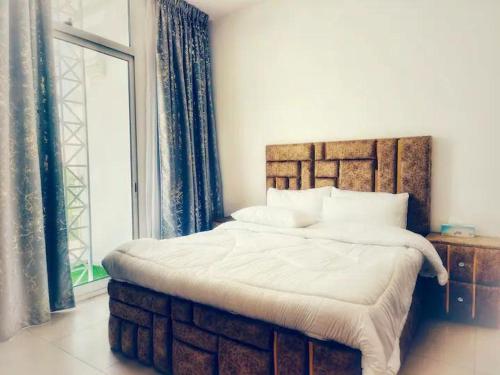 - une chambre avec un grand lit et une grande fenêtre dans l'établissement Al Wahid Holiday Homes, à Dubaï