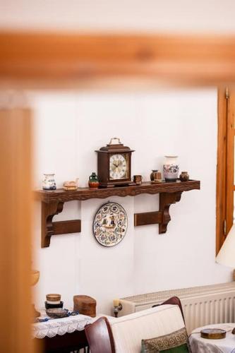 a shelf with a clock and a plate on a wall at Zeusplace Magic Villa in Aigínion