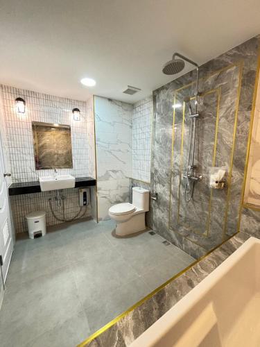 ein Bad mit einer Dusche, einem WC und einem Waschbecken in der Unterkunft Arunsakhon luxury condo in Ban Khok Kham