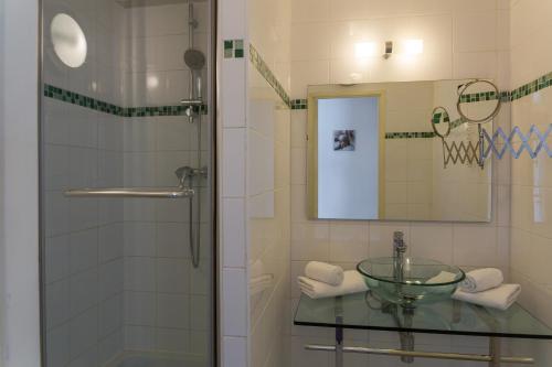 a bathroom with a glass sink and a shower at The Originals City, H&ocirc;tel Villancourt, Grenoble Sud in Le Pont-de-Claix
