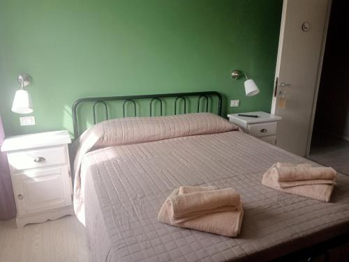 1 dormitorio con 1 cama con 2 toallas en Villa Rosetta wellnes relax, en Scrutto