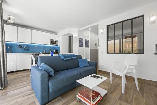 un salon avec un canapé bleu et une table dans l'établissement Cannes NG - Appartement à 10 mn du Palais des Festivals, à Cannes