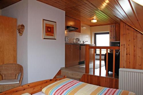 ein Zimmer mit einem Bett und einer Küche in einem Haus in der Unterkunft Ferienhof Serck - Galeriewohnung in Fehmarn