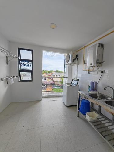 a large white kitchen with a large window in it at Jee Foh Homestay in Miri