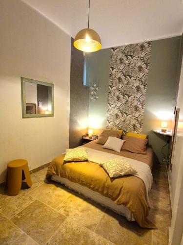 une chambre avec un grand lit dans une pièce dans l'établissement Au Lys rose, à LʼIsle-sur-la-Sorgue