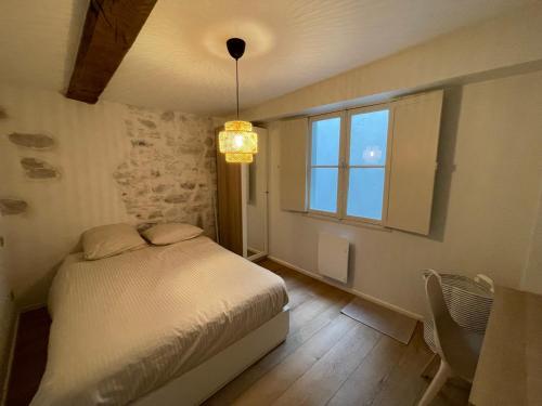 um pequeno quarto com uma cama e uma janela em Appartement hyper centre 2 chambres em Baiona