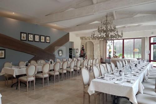 een grote eetkamer met witte tafels en witte stoelen bij Chateau Laroche-Ploquin in Sepmes