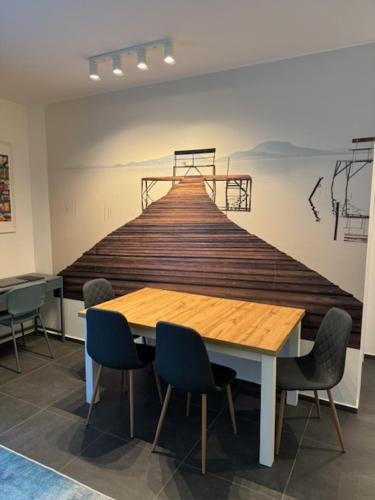 a table in a room with a painting on the wall at Fűzliget2- Pier in Balatonfůzfő