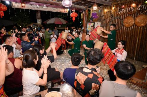 eine Gruppe von Menschen, die vor einer Menge eine Vorstellung sehen in der Unterkunft Nhà nghỉ 28 - Homestay Biên Thùy, Bản Lác, Mai Châu, Hòa Bình in Mai Châu