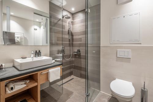 a bathroom with a toilet and a sink and a shower at Gletscherblick- serviced apartments in Obergurgl