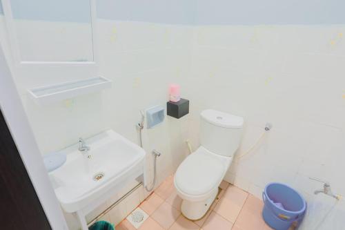 a white bathroom with a toilet and a sink at Aaira 8Pari Riverview Lodge in Kota Bharu