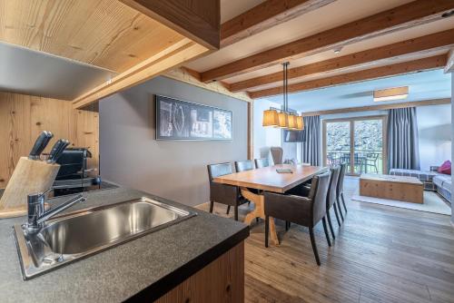 a kitchen and dining room with a sink and a table at Gletscherblick- serviced apartments in Obergurgl