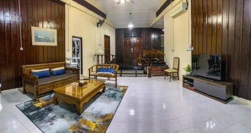 a living room with a couch and a table at Aaira 8Pari Riverview Lodge in Kota Bharu