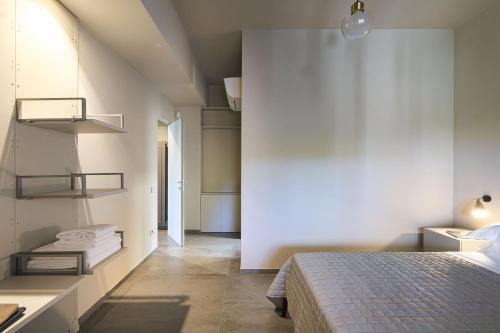 a bedroom with a bed and a white wall at Villa Bizzarria in Castellammare del Golfo