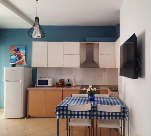 a kitchen with a table with chairs and a refrigerator at Himara Sea Sunny Home in Himare