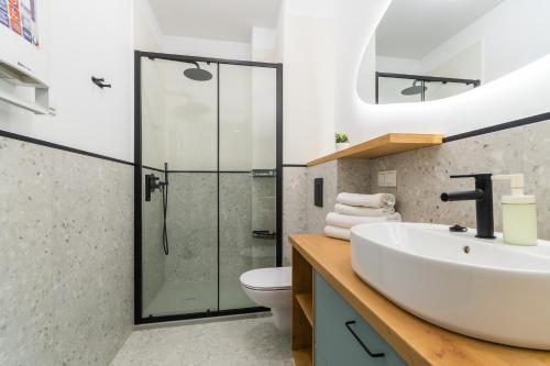 a bathroom with a sink and a glass shower at Apartamenty Mierzeja NCNK Stegna Park II - 500m od plaży in Stegna