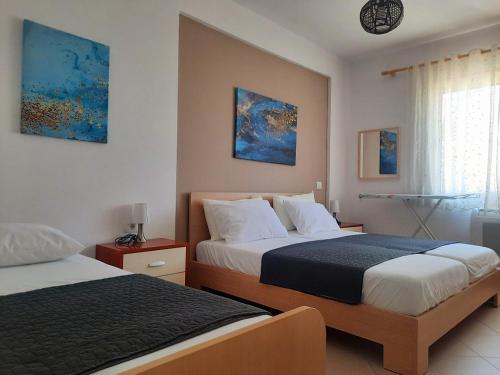 a hotel room with two beds and a window at Himara Sea Sunny Home in Himare