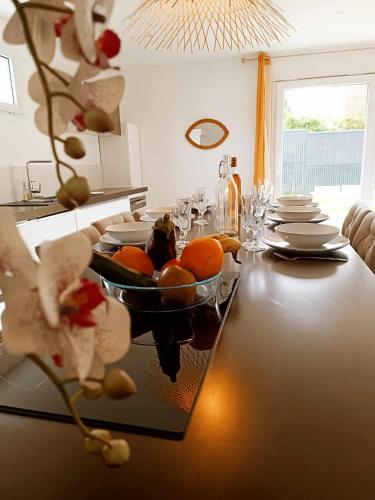 a table with a bowl of oranges on it at Pavillon proche LAC Vesoul Vaivre animaux acceptés in Andelarre