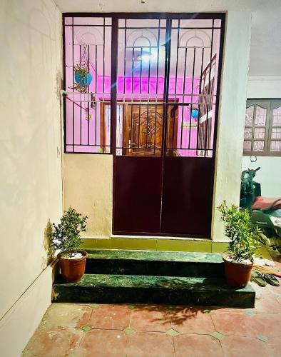 a door with two potted plants in front of it at COIMBATORE 2BHK AC Private Villa By Shivalaya -Kovaipudur- in Coimbatore