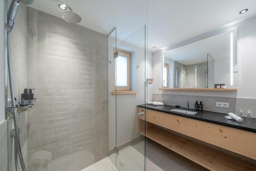 a bathroom with a glass shower and a sink at Gletscherblick- serviced apartments in Obergurgl
