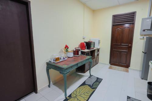 a kitchen with a table in the middle of a room at Aaira 8Pari Riverview Lodge in Kota Bharu