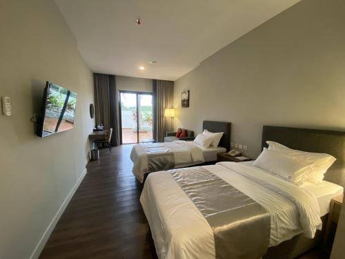 a hotel room with two beds and a window at ONYX HOTEL & VILLA in Tanjunguban