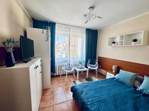 a bedroom with a bed and a television and a table at SunRise Mielno in Mielno