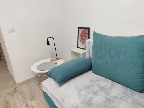 a couch with a blue pillow next to a table at Harmony House in Oradea