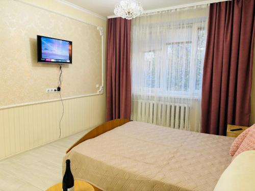 a bedroom with a bed and a tv on the wall at Paola Apartment in Chişinău