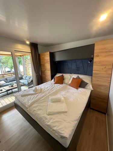 a bedroom with a large bed with a wooden headboard at Mobile Home - Sea La Vie in Biograd na Moru
