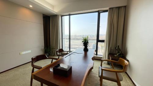 una sala de conferencias con mesa, sillas y una gran ventana en Guangzhou Xing Yi International Apartment - Poly World Branch, en Guangzhou