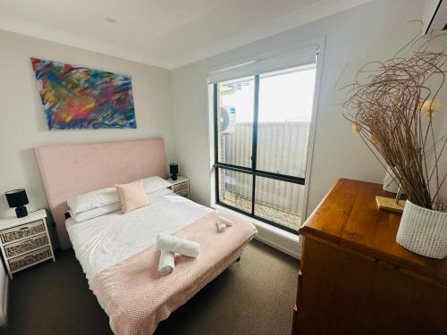 een slaapkamer met een bed en een groot raam bij Cool Air Austral with AC in Austral