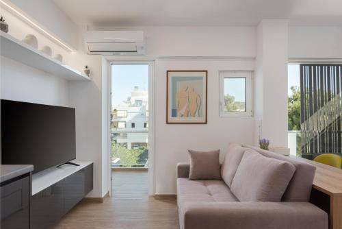 a living room with a couch and a television at Athenian Riviera Seaside Suite in Athens