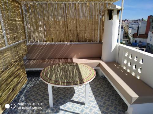 a small table on a balcony with a table at Stella Maris, Asilah medina in Asilah