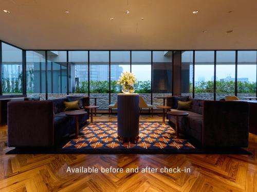 eine Lobby mit Sofas, Tischen und Fenstern in der Unterkunft Mitsui Garden Hotel Osaka Premier in Osaka