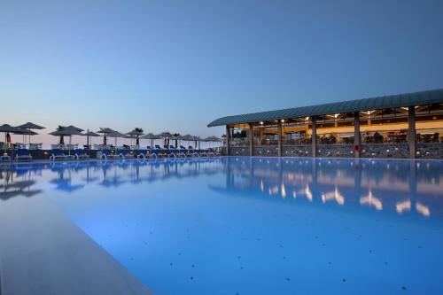 ein großer Pool mit Stühlen und Sonnenschirmen in der Unterkunft Arina Beach Resort in Kokkíni Khánion