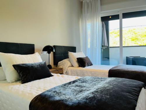 Habitación de hotel con 2 camas y ventana en Wellingtonia Lujoso apart con piscina y parking en Estepona