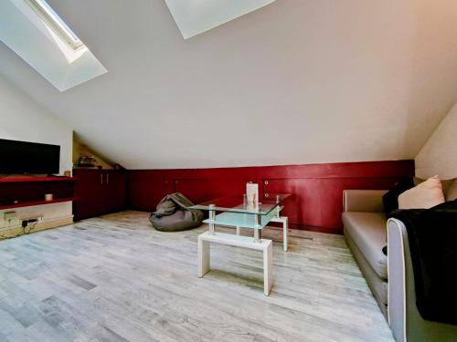 een woonkamer met een bank en een tafel bij Home - Sous les toits de Paris - Séjour à Auxerre in Auxerre