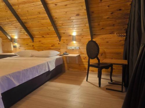 a bedroom with a bed and a desk and a chair at Motto Wood Otel in Hatay