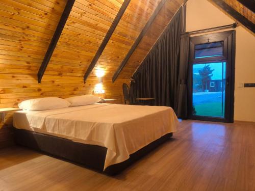 a bedroom with a bed and a large window at Motto Wood Otel in Hatay
