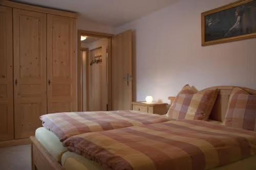 a bedroom with a bed with a plaid blanket at Ferienwohnung Grüsser-kagerhuber in Schönau am Königssee
