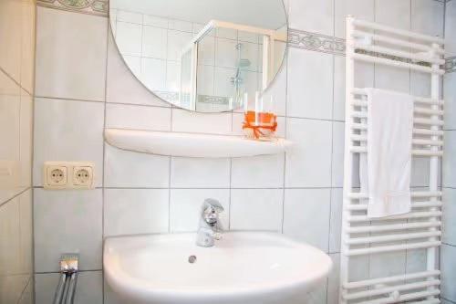 La salle de bains blanche est pourvue d'un lavabo et d'un miroir. dans l'établissement Ferienwohnung Grüsser-kagerhuber, à Schönau am Königssee