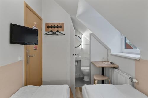 um pequeno quarto com 2 camas e uma casa de banho em Stay Express em Vilnius